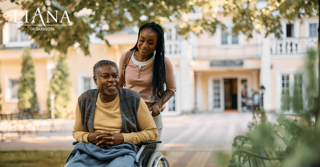 Daughter pushing her senior father in a wheelchair during the transition to assisted living