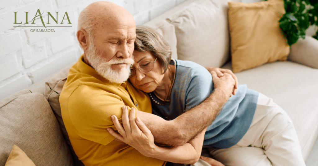 Loving senior couple embracing at home while navigating emotional changes through the stages of Lewy body dementia.