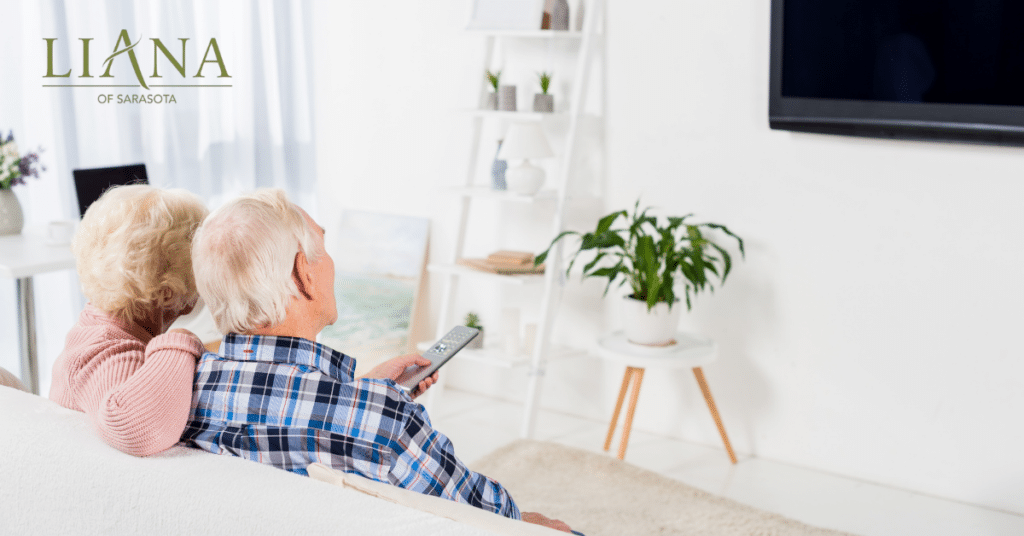Older couple relaxing at home while watching TV, used to introduce films about Alzheimer’s disease.