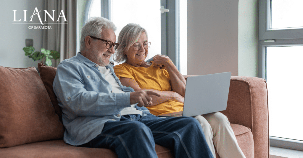 A senior couple using laptop together on a couch at home choosing senior living in Sarasota