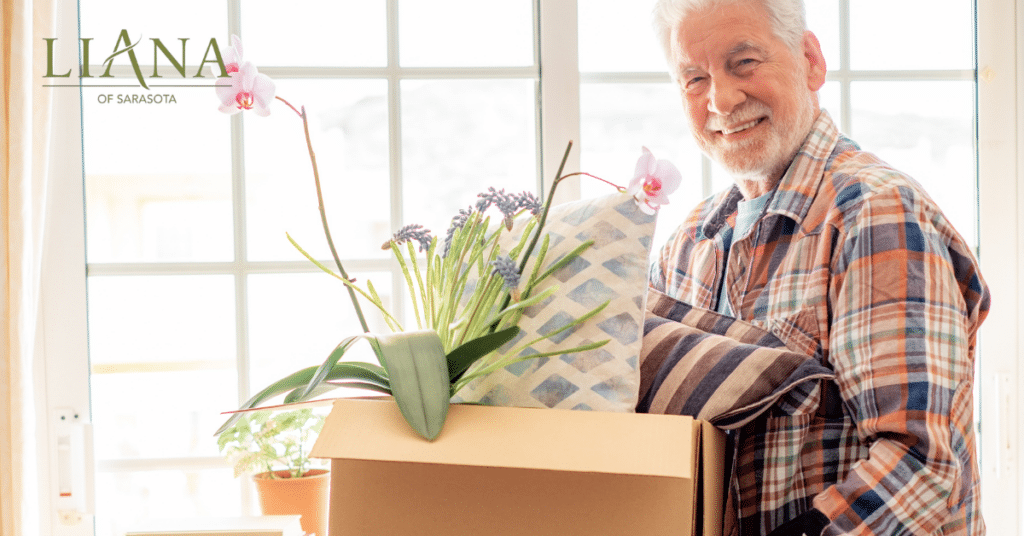 Senior man holding a moving box while preparing for a care transition and deciding when to move from assisted living to memory care
