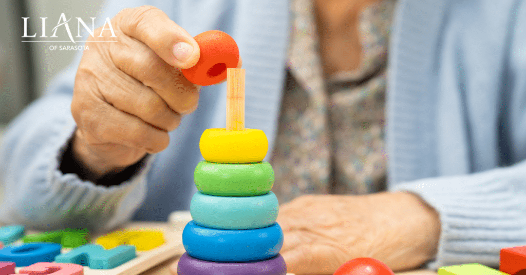 Senior engaging in a colorful stacking activity that supports cognitive care through the stages of Lewy body dementia.