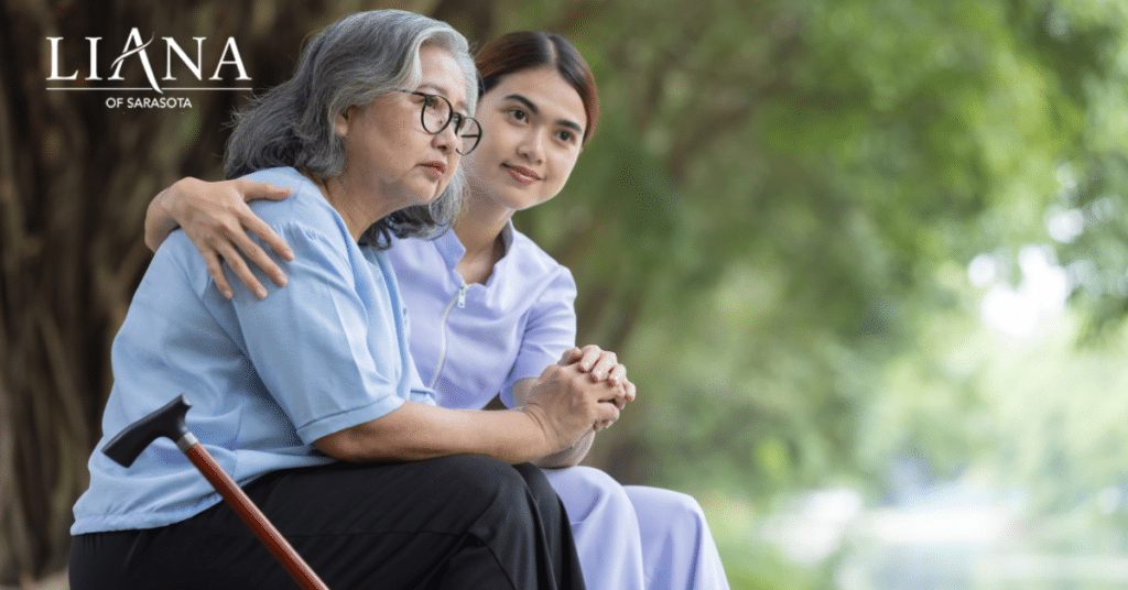 Care partner sitting with an older loved one outdoors while the family prepares to move a parent with dementia into assisted living.