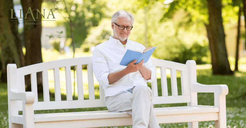 Senior man reading outdoors as part of an active lifestyle that may help prevent dementia