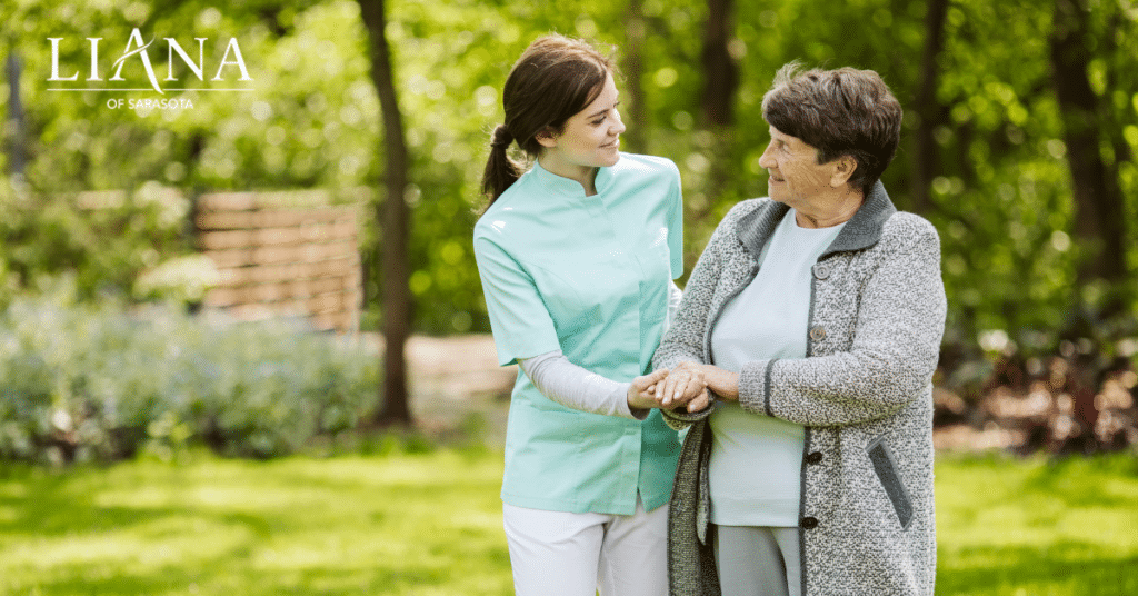 Caregiver holding hands with an older woman in a garden, showing supportive types of caregivers for daily care