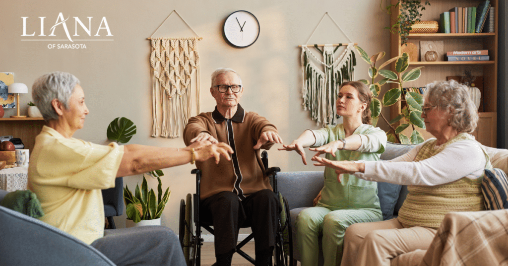 A care partner leading a seated group exercise for older adults receiving memory care services